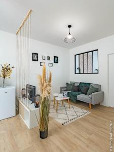 uma sala de estar com um sofá e uma mesa em La Vie est belle em Oyonnax