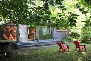 zwei rote Stühle vor einem Haus in der Unterkunft Gîte L'Orée 