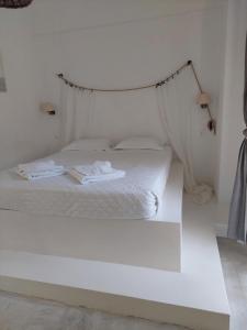 a bedroom with a white bed with a hanging bed frame at Golden Star Praxitelous in Agia Marina Aegina