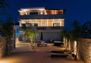 uma casa à noite com luzes acesas em ODYSSEA Top View & Hot Jacuzzi Front Beach em Kremasti