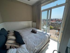 Un dormitorio con una cama con un osito de peluche encima. en Mel's apartment 2, en Zandvoort