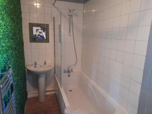 a bathroom with a sink and a shower and a tub and a sink at Plymouth Professionals Apartment in Plymouth