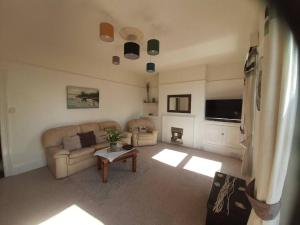 Plymouth Professionals Apartment في بلايموث: غرفة معيشة مع أريكة وطاولة