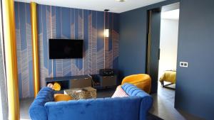 uma sala de estar com um sofá azul e uma televisão em Middelburg Koperwiek em Middelburg