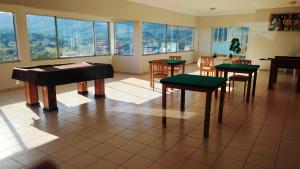 une chambre avec des tables, des chaises et un piano dans l'établissement Flat DiRoma perto do Hot Park, à Rio Quente