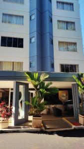 a large blue building with palm trees in front of it at Flat DiRoma perto do Hot Park in Rio Quente