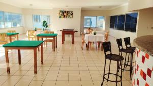 une salle à manger avec des tables, des chaises et une table dans l'établissement Flat DiRoma perto do Hot Park, à Rio Quente