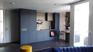 uma cozinha com armários azuis e uma mesa num quarto em Middelburg Koperwiek em Middelburg