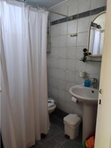 a bathroom with a white shower curtain and a toilet at Sunny Room Lefkada in Lygia