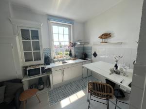 a kitchen with a sink and a table with a microwave at Mel's apartment 2 in Zandvoort