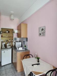 a kitchen with a table and a white refrigerator at Sunny Room Lefkada in Lygia