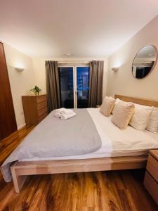 a bedroom with a large white bed with a window at Canary Wharf, E14 9PW, 2 Bedroom Apartment in London