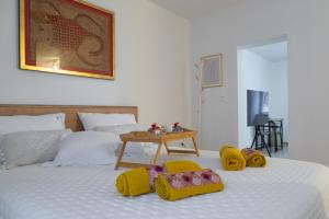 ein Schlafzimmer mit einem Bett mit gelben Hausschuhen darauf in der Unterkunft San Teodoro in Split