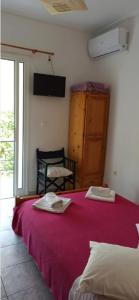 a bedroom with a bed with a red blanket and a window at Sunny Room Lefkada in Lygia