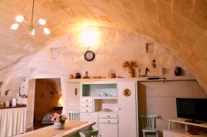 una stanza con un armadietto bianco e un orologio sul muro di Casa Contini a Matera