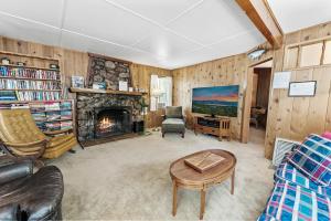 een woonkamer met een bank en een open haard bij The Petite Cabin - Rustic and Cozy! Perfect place to unwind and relax! Close to Village in Big Bear Lake