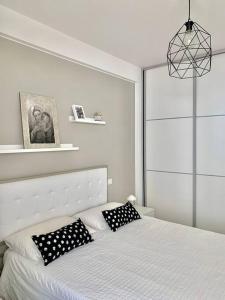 1 dormitorio con 1 cama con almohadas blancas y negras en Casa vacanze/soggiorno lavoro a porto san Giorgio, en Porto San Giorgio