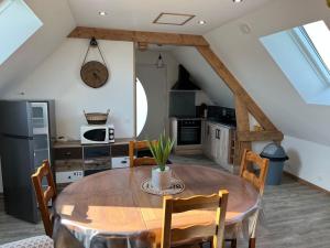 eine Küche mit einem Holztisch und Stühlen im Zimmer in der Unterkunft Le Paradis de la Seine 