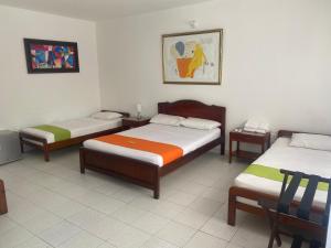 a room with three beds in a room at Hotel Villa Ricaurte in Girardot