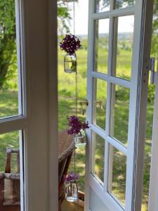 a door with a window with purple flowers in it at Hyggelig country Lodge in Stenstrup