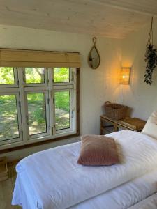 a bedroom with a large white bed and windows at Hyggelig country Lodge in Stenstrup
