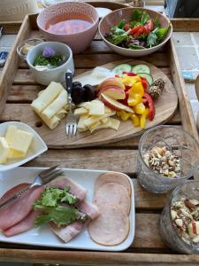 a wooden table topped with different types of food at Hyggelig country Lodge in Stenstrup