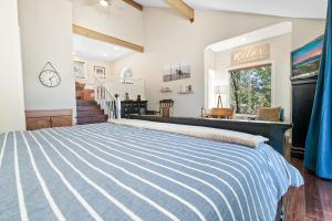 1 dormitorio con cama de rayas azul y blanco en BB Lake View Lodge - Gorgeous Lakeviews, Hot Tub, Jetted Tub, and Firepit!, en Big Bear Lake
