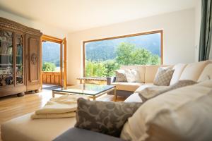 ein Wohnzimmer mit einem Sofa und einem großen Fenster in der Unterkunft Idyllisches Berg-Chalet mit Panoramablick in Bayrischzell