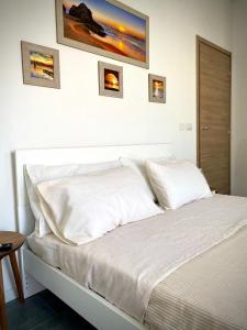 Una cama blanca con dos almohadas encima. en b&b Casa Balai 72 a 150 mt dal mare en Porto Torres