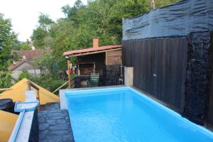 a swimming pool in a backyard with a black building at Recanto do Sol in Vieira do Minho