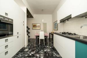 Gold Sweet Home في لا سبيتسيا: مطبخ فيه دواليب بيضاء وطاولة فيه