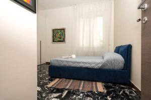 Gold Sweet Home في لا سبيتسيا: غرفة نوم بسرير ازرق ونافذة