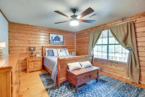 Schlafzimmer mit einem Bett und einem Deckenventilator in der Unterkunft Cape Royale Luxury Livingston Cabin with Hot Tub! in Coldspring