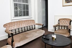 a living room with a couch and a table at The Water Works Cottage in London