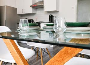 una mesa de cristal con sillas y copas de vino. en The Water Works Cottage en Londres