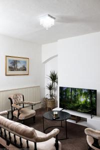 a living room with a large flat screen tv at The Water Works Cottage in London
