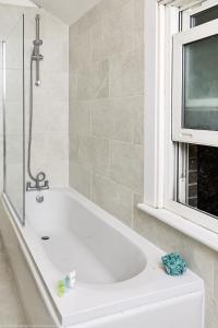 a bath tub in a bathroom with a tv at The Water Works Cottage in London