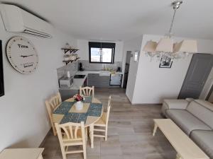 uma cozinha e sala de estar com uma mesa e um sofá em Charmante Maison avec Piscine em Bessan