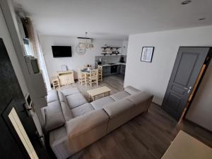 uma sala de estar com um sofá e uma cozinha em Charmante Maison avec Piscine em Bessan