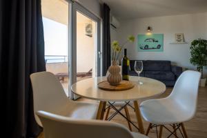ein Wohnzimmer mit einem Tisch und weißen Stühlen in der Unterkunft Lea Apartments in Drage