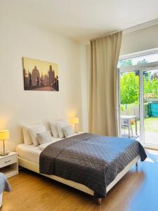 a bedroom with a bed and a large window at Maria Apartments - Free Parking in Prague