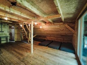 Pokój ze skórzanymi fotelami w pokoju z drewnianymi sufitami w obiekcie Szczerbanówka na Maniowie w mieście Maniów