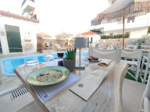 a table with a plate of food on it on a patio at Koukounari Apartments in Skala