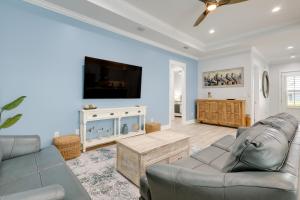 a living room with a couch and a flat screen tv at Bright Foley Home with Patio - 7 Mi to Wharf and Beach in Foley