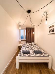 um quarto branco com uma cama num quarto em Ul SZOPY 2 APARTAMENTY ZRESETUJ SIĘ W GDAŃSKU em Gdansk