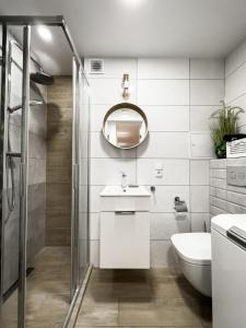 uma casa de banho com um chuveiro, um lavatório e um espelho. em Ul SZOPY 2 APARTAMENTY ZRESETUJ SIĘ W GDAŃSKU em Gdansk