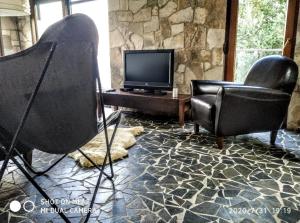 Holiday home Haustor with Skadar lake view في بودغوريتسا: غرفة معيشة مع كرسيين وتلفزيون