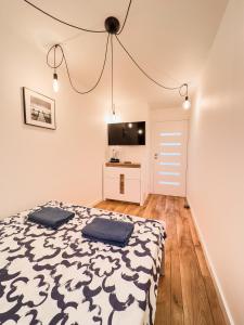 a bedroom with a bed and a flat screen tv at Ul SZOPY 2 APARTAMENTY ZRESETUJ SIĘ W GDAŃSKU in Gdańsk