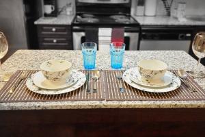 a table with two cups and plates and glasses at Lakeview Condo in Downtown with Free Parking. in Toronto