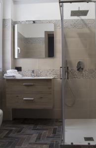 bagno con doccia, lavandino e specchio di Incanto Luxury Rooms a Lampedusa